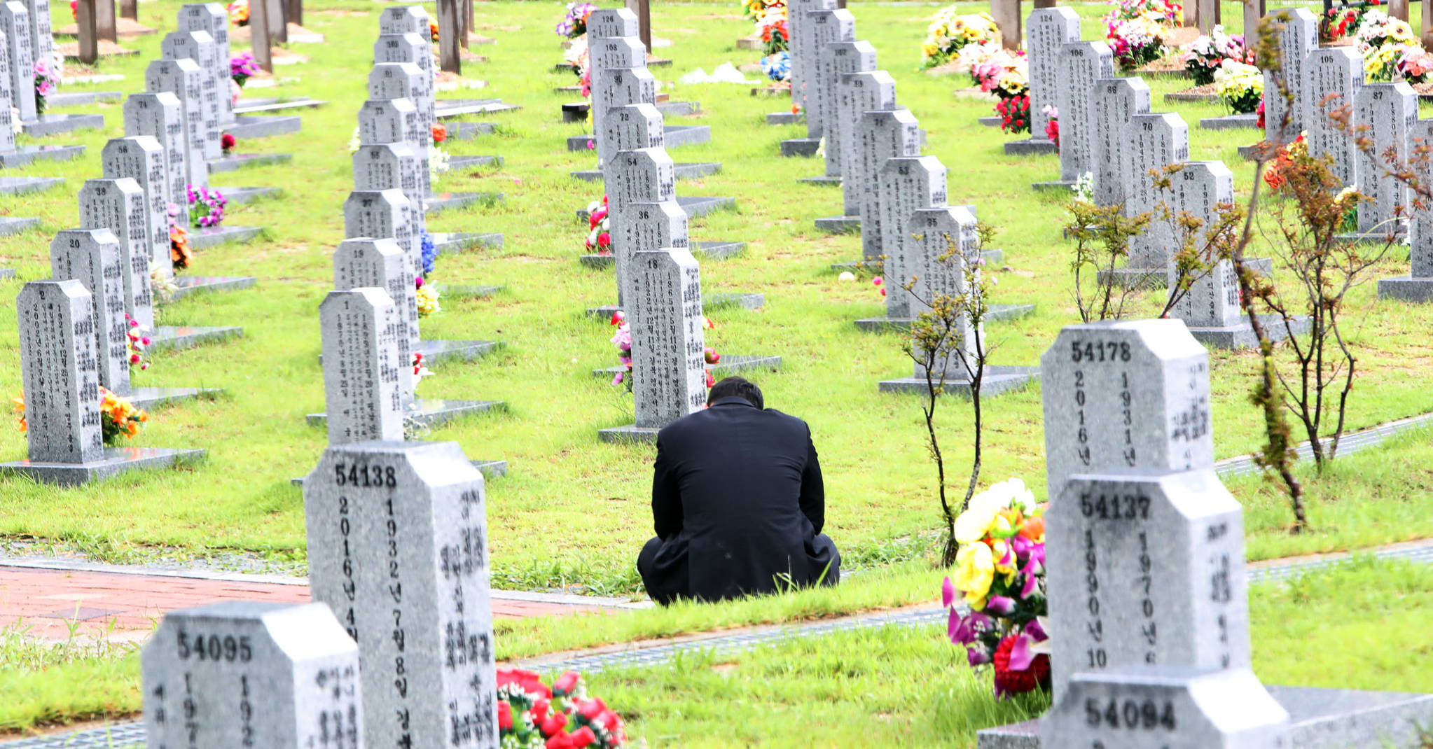 21일 오후 대전현충원에서 열린 K-9 자주포 사고 희생자인 이태균(26) 상사의 안장식을 찾은 이 상사의 친구가 자리를 떠나지 못한 채 묘역 앞에 앉아있다.[연합뉴스]