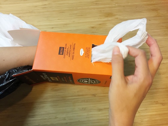 줄줄이 엮은 비닐봉지의 첫 번째 봉지 손잡이를 박스 밖으로 조금 내놓은 후, 다른 봉지들을 박스 안으로 밀어 넣는다.