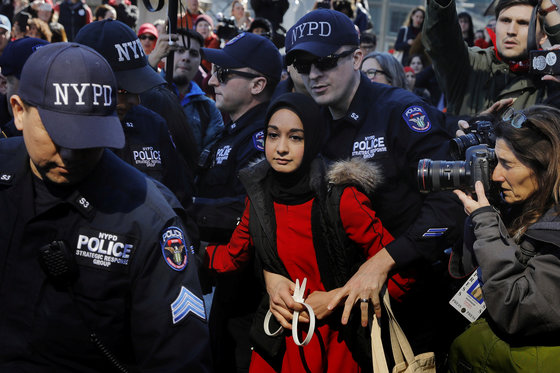3월 8일. 뉴욕 경찰이 세계 여성의 날을 맞아 '여성 없는 날' 행진에 참여한 한 여성을 체포하고 있다. [REUTERS=연합뉴스/Lucas Jackson]