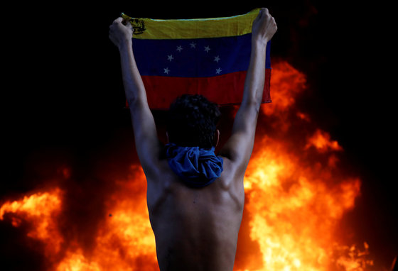 6월 12일. 베네수엘라 니콜라스 마두로 정권에 맞서 시위를 벌인 남성이 국기를 들고 있다. [REUTERS=연합뉴스/Carlos Garcia Rawlins]