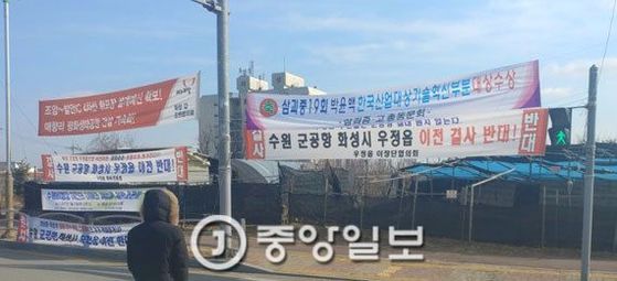 올해 초 수원 군공항 이전 예비후보지인 화성 화옹지구와 맞닿은 우정읍의 한 교차로에 ‘생활터전 망가진다, 수원 군공항 화성시 우정읍 이전 반대!’ 등의 문구가 적힌 현수막들이 걸려 있다. [중앙포토]