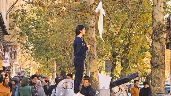 히잡 착용을 강요하는 이란 정부에 항의하는 의미에서 히잡을 막대 끝에 건 채 거리 시위를 벌이고 있는 비다 모바헤드. 31세의 아기 엄마인 모바헤드는 이 사건으로 경찰에 체포됐다가 한달만에 석방됐다. [사진 페이스북]