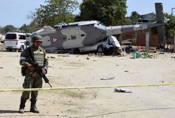  강진 피해지역 시찰에 나선 멕시코 내무장관 등이 탑승한 헬리콥터가 16일(현지시간) 피노테파 나시오날 지역에서 추락해 13명이 숨졌다. 군인이 사고현장을 통제하고 있다. [AFP=연합뉴스}