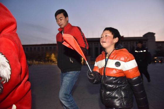 왕푸만은 유명해진 뒤 후원을 받아 지난 1월 사흘간 수도 베이징을 여행했다. 베이징 톈안먼 광장에서 국기게양식을 보기 위해 걸어가는 왕푸만. [사진 바이두 캡처]