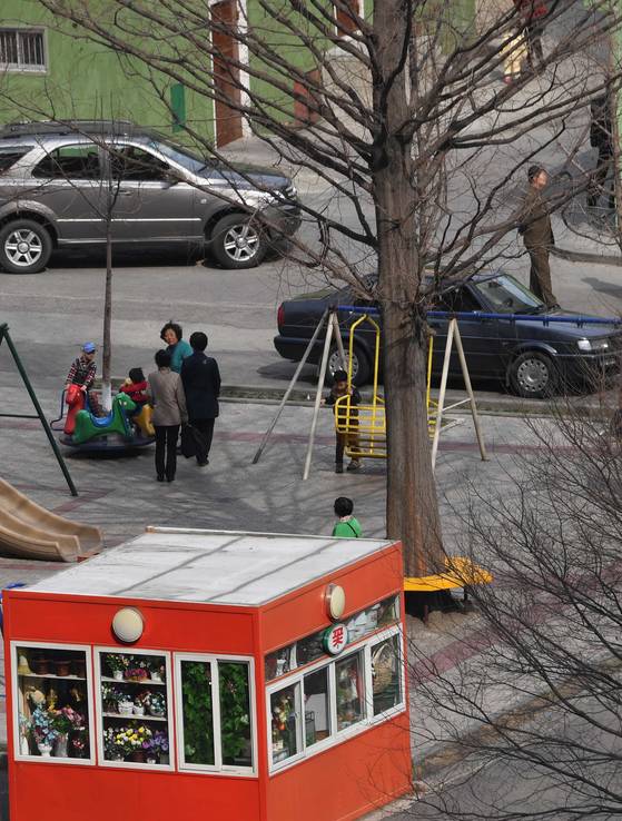 평양 고려호텔 인근 공원에 작은 꽃집 너머로 북한 어린이들이 놀이기구를 타고 있다. 평양=사진공동취재단