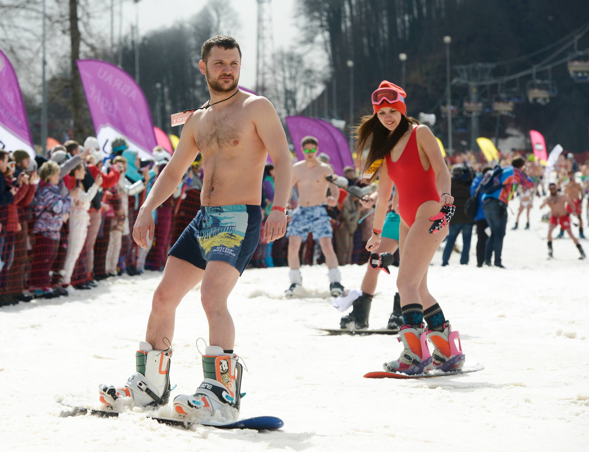 31일 러시아 소치 로사 후토르 스키 리조트에서 열린 부겔우겔 축제에서 수영복을 입은 참가자들이 활강하고 있다. [타스=연합뉴스]