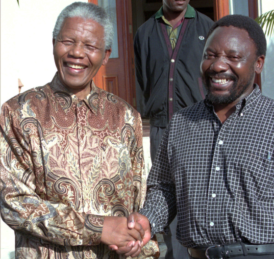 FILE - In this April 13, 1996 file photo South African President Nelson Mandela, left, shakes hands with the ANC Secretary General, Cyrill Ramaphosa, after Mandela announced Ramaphosa's resignation as a Member of Parliament, in Cape Town, South Africa. Ramaphosa now faces the challenge of leading one of Africa's most powerful economies out of a swamp of corruption scandals that bought down former leader Jacob Zuma. (AP Photo, File) <저작권자(c) 연합뉴스, 무단 전재-재배포 금지>