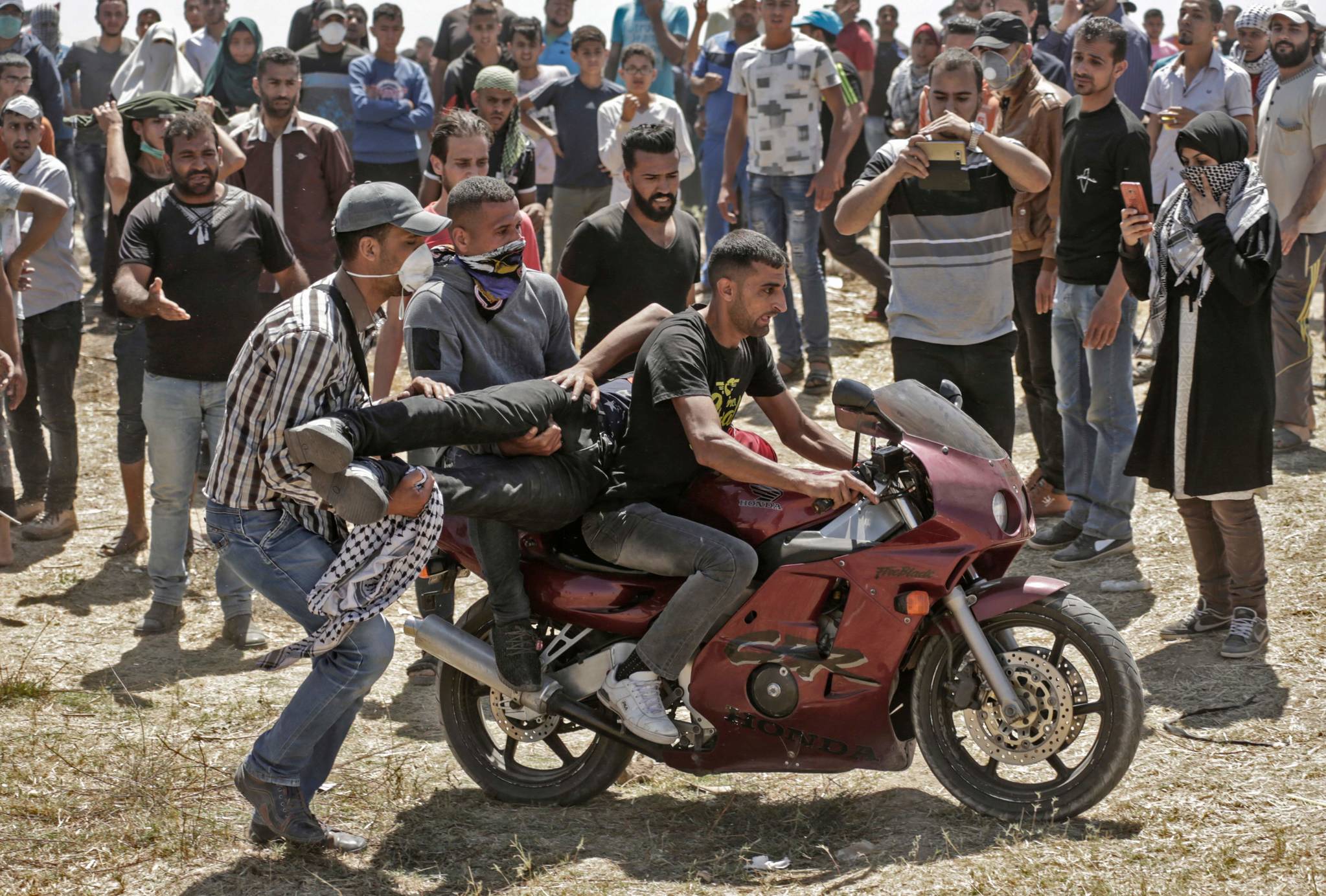 팔레스타인들이 모터사이클을 이용해 부상자를 옮기고 있다. [AFP=연합뉴스]