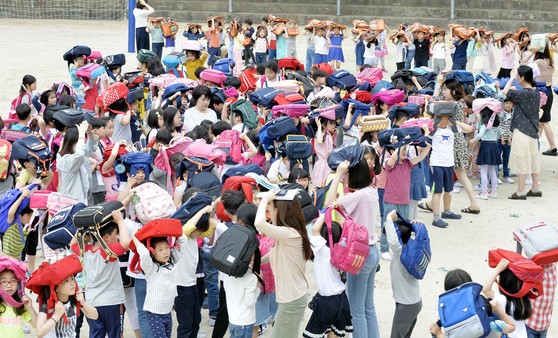 16일 오전 지진 대피훈련이 진행된 대전 서구 선암초등학교에서 학생들이 머리를 보호하기 위해 가방을 위로 들고 운동장으로 대피하고 있다. 프리랜서 김성태