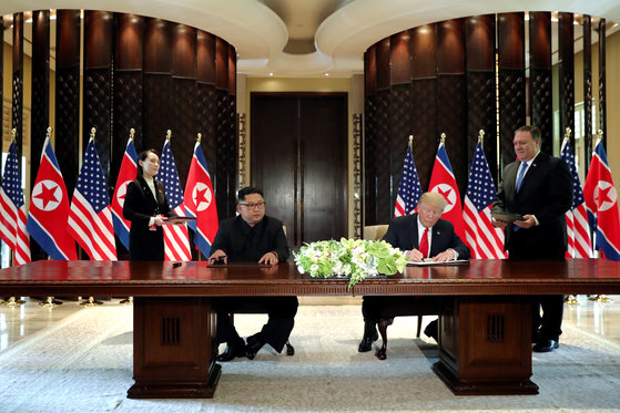 도널드 트럼프 미국 대통령과 김정은 북한 국무위원장이 12일 싱가포르 카펠라 호텔에서 공동성명에 서명하고 있다. [로이터=연합뉴스]