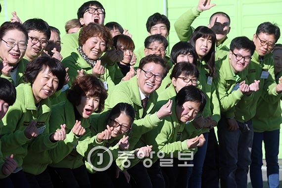 김만석 사장(가운데 안경 쓴 이)이 직원들과 함께 웃고 있다. 태건상사는 직원 98명 중 48명이 장애인으로, 폐자재를 활용한 전기부품 생산업체답게 유니폼도 ‘친환경’을 의미하는 녹색으로 맞췄다. [사진 최정동 기자]