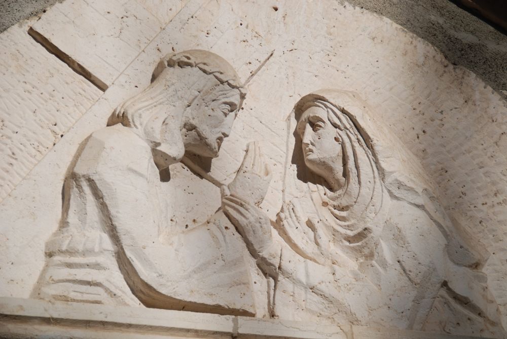 어머니 마리아가 십자가를 짊어진 아들 예수의 손을 잡고 있다.