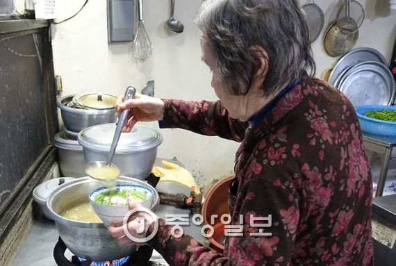 끓는 국물로 미나리를 토렴하는 ‘남포식당’ 주인 팔순의 박옥순 여사. 국물 색이 다른 집과 다르다. 토렴한 미나리는 끓이는 것과 다르게 씹히는 질감이 무척 아삭하고 향도 더 좋다.