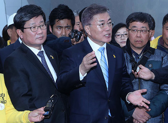 문재인 더불어민주당 대통령 후보(가운데)가 6일 반잠수 선박에 실린 세월호가 있는 목포신항을 찾아 해양수산부 직원과 이야기하고 있다. [오종택 기자]
