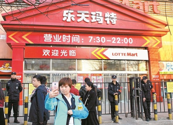 3월 13일 중국 베이징에서 한 여성이 영업정지된 롯데마트를 배경으로 셀카를 찍고 있다. 중국 당국은 지난달 초 중국 내 롯데마트 점포 60여 개에 소방규정 위반을 이유로 영업정지 처분을 내렸다. [중앙포토]