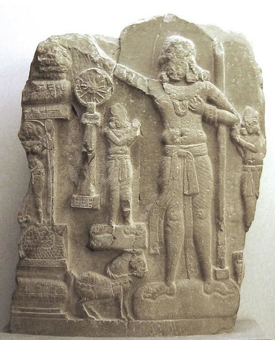 아소카 왕을 새긴 조각상. 오른쪽에 서 있는 인물이 아소카 왕이고, 붓다의 가르침을 상징하는 바퀴 모양의 법륜도 보인다.  