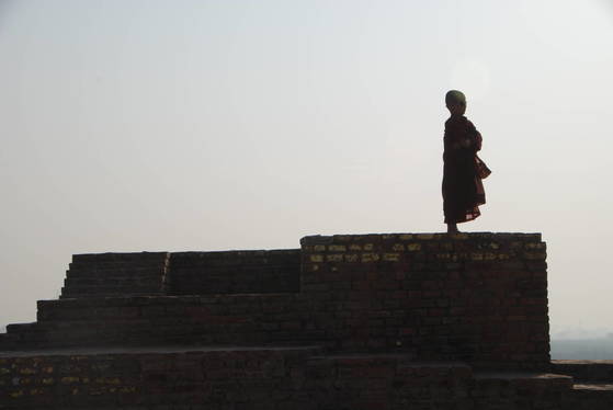 인도의 불교 유적지에 있는 탑 위에 한 동자승이 서 있었다. 그는 무엇을 찾고 있는 걸까.