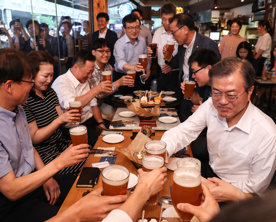 문재인 대통령이 지난 7월 26일 오후 서울 광화문 인근 한 맥줏집에서 퇴근길 시민들과 만나 건배하고 있다. 이 날 행사는 대통령 후보 시절 약속한 '퇴근길 국민과의 대화 일환'으로 열렸다. [연합뉴스]