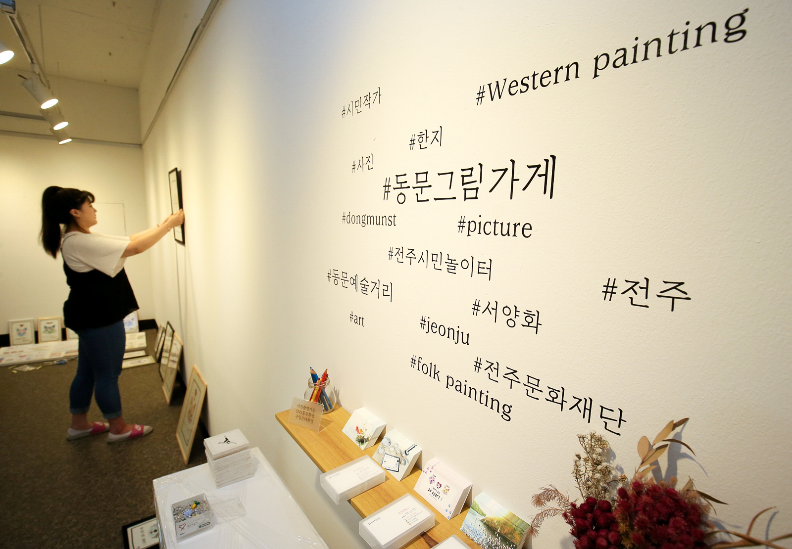 지난 9일 전주시민놀이터 1층 갤러리 공간에서 일러스트 작가 박소연(27·여)씨가 그림을 벽에 진열하고 있다. 프리랜서 장정필