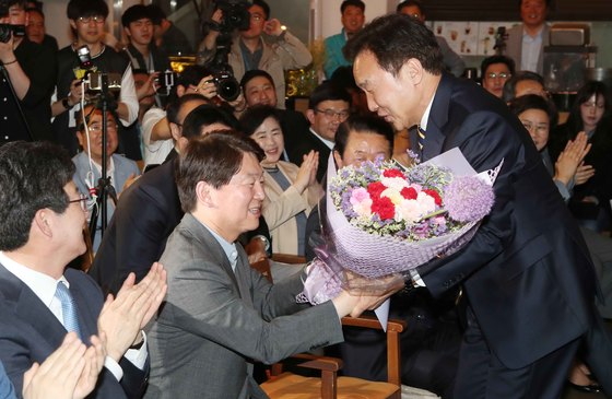 손학규 대표는 바른미래당 창당에 찬성했다. 지난 6월 지방선거당시 선거대책본부장을 맡아 안철수 서울시장후보를 지원했다. 손 대표가 꽃다발을 안 후보에게 전달하고 있다. 왼쪽은 유승민 당시 바른미래당 공동대표. [중앙포토]