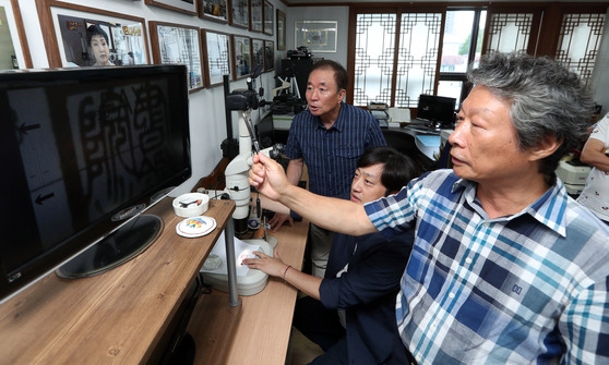 법과학조합원들이 문서감정 장비로 인감을 분석하고 있다. 강정현 기자