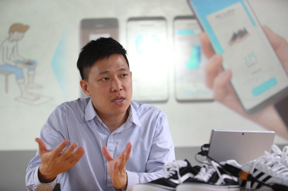 스마트폰으로 발 사이즈를 정확히 측정해 맞는 신발을 골라주는 슈픽(SHOEPIK) 앱을 개발한 김주형 디파인드(DEFIND) 대표가 1일 서울 삼성동 본사에서 사용법을 설명하고 있다. [오종택 기자]