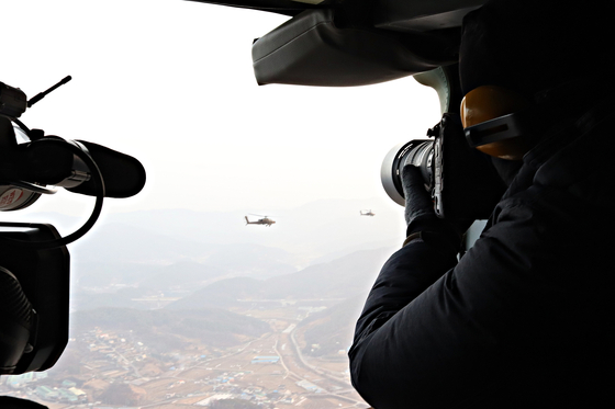 19일 기지를 이륙해 태안으로 비행하는 아파치 편대를 UH-60 헬기에서 촬영하고 있다. [박용한]