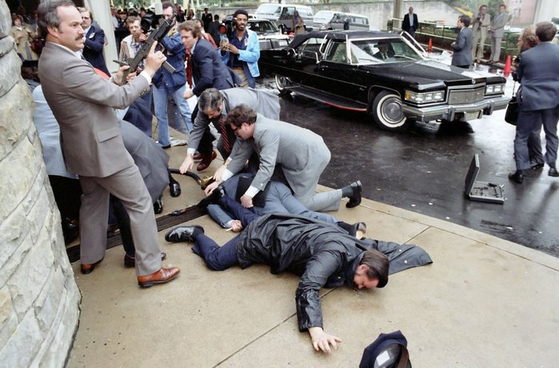 1981년 3월 로널드 레이건 미국 대통령이 총격 피습을 당했던 당시 현장 사진. 전문가들은 "당시 대통령 경호원들이 늘 들고 다니던 서류가방에서 잽싸게 기관단총을 꺼내들었다"고 말했다. 우측 도로에 기관단총을 휴대하는 서류가방이 떨어져 있다.