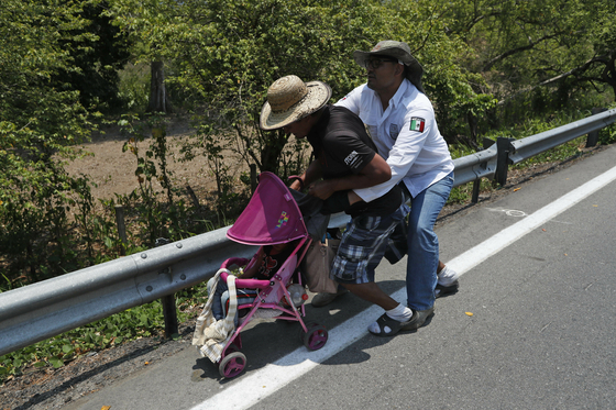멕시코 이민청 요원이 22일(현지시간) 치아파스 주 피히히아판 외곽에서 유모차를 밀고 가는 중미 이민자를 체포하고 있다. [AP=연합뉴스] 