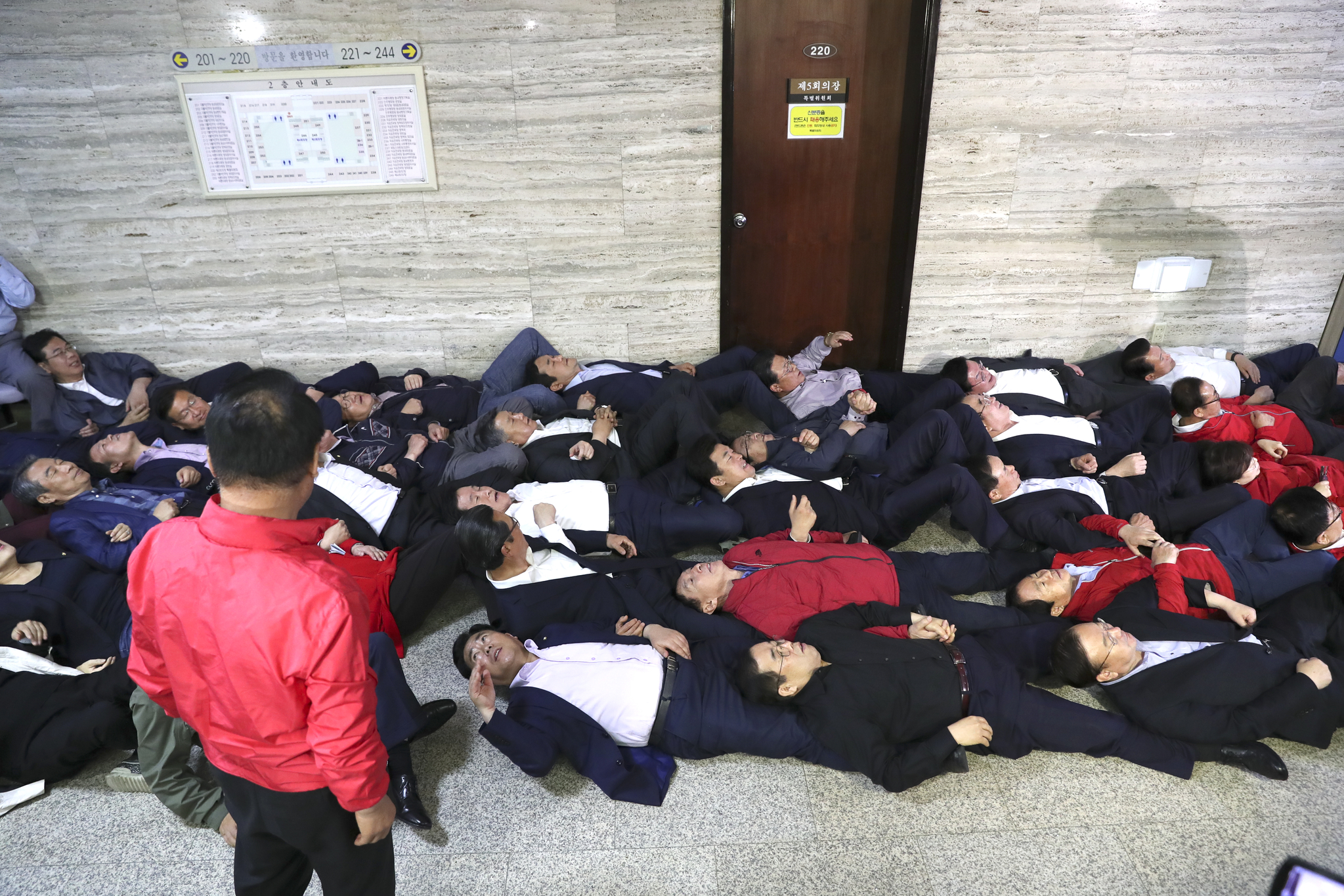 자유한국당 의원들이 26일 오후 국회 사개특위 회의실 앞에서 민주당의 진입을 차단하기 위해 홍철호 의원의 신호에 따라 바닥에 눕고 있다. 임현동 기자