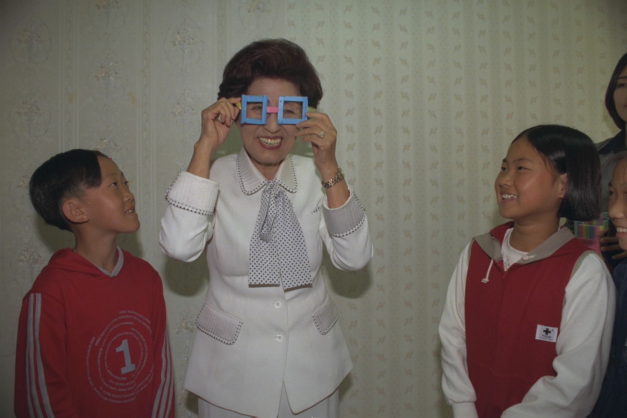 1998년 이희호 여사가 충남 금산 어린이복지시설 향림원을 방문 어린이들이 만든 수수깡 안경을 쓰고 있다. [중앙포토] 