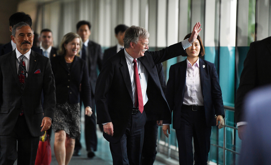 존 볼턴 미국 백악관 국가안보회의(NSC) 보좌관이 24일 서울 종로구 외교부 청사에서 강경화 외교부 장관과의 면담을 위해 이동 중 '존 볼턴 방한 항의' 집회 참석자들을 향해 손 흔들고 있다. 변선구 기자