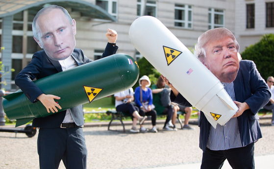 도널드 트럼프 미국 대통령과 블라디미르 푸틴 러시아 대통령의 가면을 쓰고 가짜 핵폭탄을 든 두 독일인이 베를린 미국 대사관 앞에서 중거리핵전력조약(INF) 폐기에 항의하는 퍼포먼스를 벌이고 있다. [EPA=연합뉴스] 