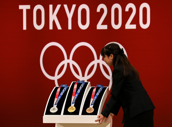 도쿄올림픽·패럴림픽을 1년 앞둔 지난 7월 24일 도쿄에서 열린 행사장에서 금, 은, 동메달을 공개하고 있다. 2020년 도쿄 올림픽 패럴림픽이 과거사를 묻고 일본을 전쟁 할 수 있는 나라로 만들려는 아베 퐁리의 정치적 행사로 변질될 수 있다는 우려가 나오고 있다. [EPA=연합뉴스] 