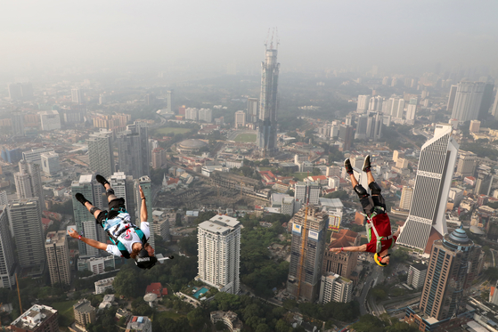 26일(현지시간) 말레이시아 쿠알라룸푸르에서 열린 '인터내셔널 점프 말레이시아 2019' 행사에서 베이스 점퍼가 쿠알라룸푸르 타워에서 뛰어내리고 있다. [로이터=연합뉴스]