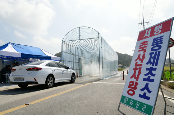 지난 4일 충남 홍성군 은하면의 거점소독시설에서 아프리카돼지열병(ASF) 확산을 막기 위한 차량 소독이 진행되고 있다. [연합뉴스]