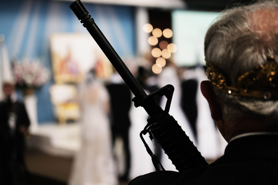14日サンクチュアリ教会で開かれた合同結婚式礼拝式に参加したある信徒がAR-15半自動小銃を持っている。[AFP =連合ニュース]