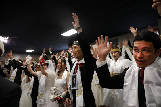 14日サンクチュアリ教会で開かれた合同結婚式礼拝式に参加したカップルが文亨進牧師の司式で結婚の誓いをしている。[AFP =連合ニュース] 