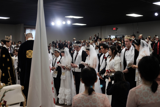 14日、米国ペンシルバニア州ニューポンドランドサンクチュアリ教会で合同結婚礼拝式文亨進牧師（左第二）司式で開かれている。[AFP =連合ニュース]