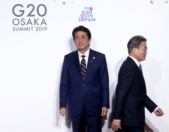 문재인 대통령이 지난 6월 28일 오전 인텍스 오사카에서 열린 G20 정상회의 공식환영식에서 의장국인 일본 아베 신조 총리와 악수한 뒤 이동하고 있다. [연합뉴스]