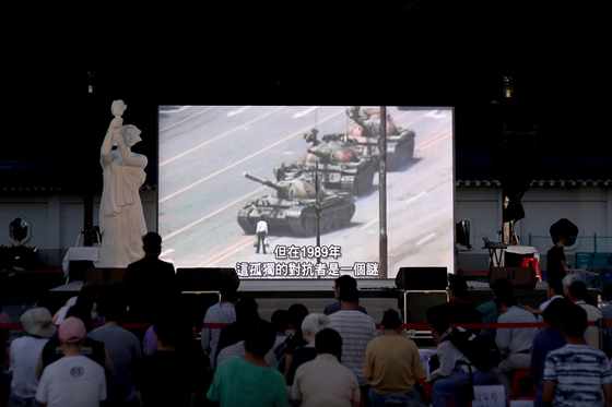지난 6월 4일 대만 타이페이에서 톄안먼 민주화 시위 30주년을 맞아 열린 추모식에서 시민들이 '탱크맨' 사진을 보고 있다. [EPA=연합뉴스]