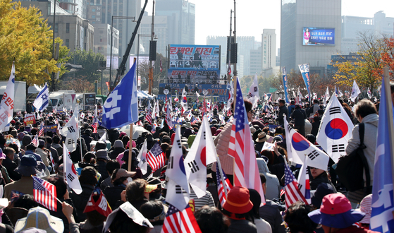 9일 오후 서울 광화문 교보빌딩 앞에서 문재인하야범국민투쟁본부 주최로 열린 대한민국 바로 세우기 국민대회에서 참가자들이 구호를 외치며 태극기와 손팻말을 흔들고 있다. [연합뉴스]