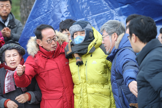 엿새째 단식 중인 자유한국당 황교안 대표(가운데)가 새로 설치된 단식 천막으로 이동하기 위해 25일 서울 종로구 청와대 분수대 앞 원래 설치돼있던 천막을 나서고 있다.[연합뉴스]