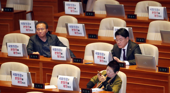 자유한국당 의원들이 29일 서울 여의도 국회 본회의장에서 '국회의장은 본회의를 개의하라'는 팻말을 붙여 놓고 개의를 기다리고 있다. [뉴스1]