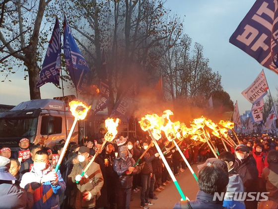 민중대회 참가자들이 서울 종로구 청와대 앞에서 횃불을 켜고 있다. [뉴시스]