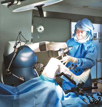 의사가 마코 로봇팔을 잡고 수술하는 모습.
