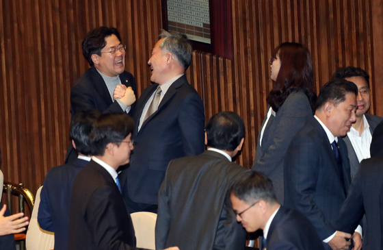 30일 국회 본회의에서 정의당 윤소하 의원이 발의한 '고위공직자범죄수사처법(공수처법)'이 통과된 후 정회되자 더불어민주당 박찬대(왼쪽), 표창원 의원이 환하게 웃으며 회의장을 나서고 있다. [연합뉴스]