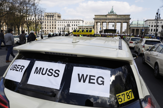 독일 베를린에서 지난해 4월 열린 우버 반대 집회에 참가한 택시. "우버는 떠나라"는 문구를 붙인 택시의 모습. [EPA]