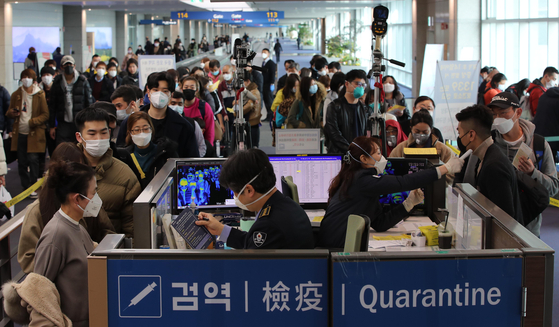 29일 중국 광저우에서 출발한 항공기 여객들이 인천국제공항 제1터미널을 통해 입국하며 발열 검사 및 검역 질의서를 제출받고 있다. 최정동 기자