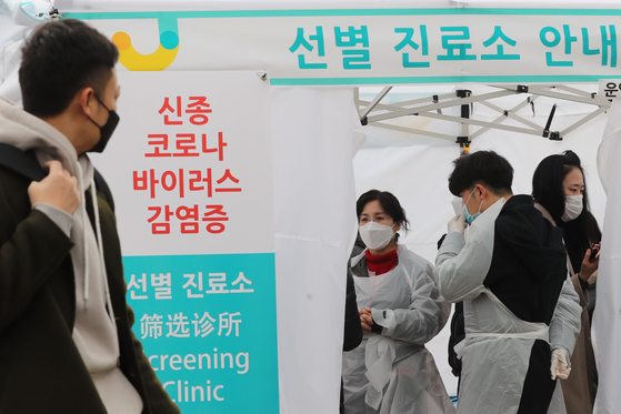 1일 오후 서울 중구 명동역 인근 거리에 신종 코로나바이러스 감염증의 유입과 확산을 방지하기 위해 설치된 중구보건소 선별진료소 앞으로 관광객이 지나가고 있다. [연합뉴스]